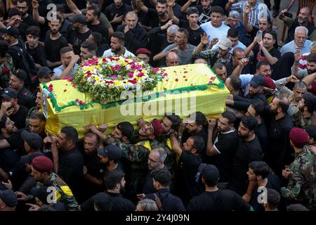 18 settembre 2024, Libano, Beirut: I sostenitori di Hezbollah trasportano la bara di una vittima uccisa in un'esplosione di cercapersone elettronico, durante una processione funebre nel sobborgo meridionale di Beirut. Migliaia di persone sono state ferite nel cyberattacco e 12 sono state uccise finora nell'ultimo bilancio annunciato dal ministero della salute. Hezbollah ha incolpato Israele per le esplosioni del 17 settembre e ha promesso ritorsioni. Molti dei suoi combattenti, così come rappresentanti di alto rango e membri della Radwan Force, un'unità d'élite all'interno del gruppo, si dice che siano tra le vittime. Foto: Marwan Naamani/dpa Foto Stock