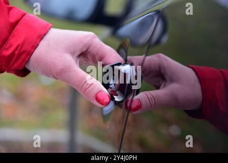 Una donna apre la porta di un'autovettura Foto Stock