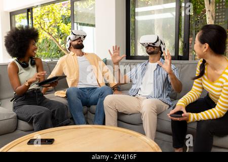 Utilizzando i visori per la realtà virtuale, diversi amici possono vivere l'esperienza di realtà virtuale insieme all'interno Foto Stock