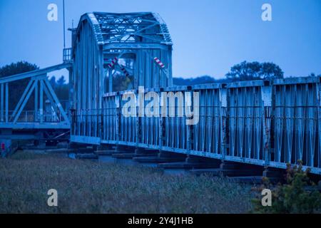 Pruchten, Germania. 17 settembre 2024. Il vecchio ponte di Meiningen aperto tra la penisola del Mar Baltico di Fischland-Darß-Zingst e la terraferma dopo il tramonto. Il ponte fu costruito nel 1910 come ponte ferroviario e utilizzato come ponte stradale dopo la seconda guerra mondiale. Crediti: Jens Büttner/dpa/Alamy Live News Foto Stock