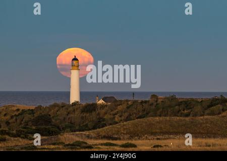 East Lothian, Scozia, Regno Unito, 18 settembre 2024. Meteo nel Regno Unito: La luna piena, una superluna conosciuta come la luna di Harvest sorge sopra il faro sulla costa. Crediti: Sally Anderson/Alamy Live News Foto Stock