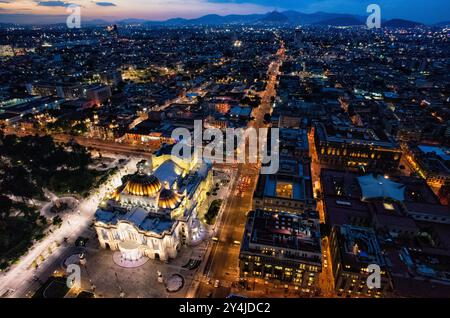 Palacio De Bellas Artes città del Messico | CITTÀ DEL MESSICO, Messico - il tramonto si adagia sul Centro Histórico mentre la cupola illuminata del Palacio de Bellas Artes offre un'ampia vista dello skyline dalla piattaforma di osservazione della Torre Latinoamericana. Completata nel 1956, la torre di 44 piani è stata l'edificio più alto del Messico per decenni e si affaccia sulla cupola in ceramica smaltata del palazzo tra le montagne che circondano la Valle del Messico. Foto Stock