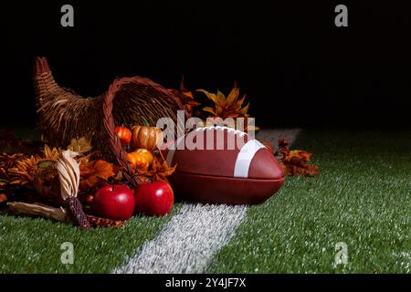Una cornucopia con un calcio su un campo di erba con strisce e sfondo scuro Foto Stock