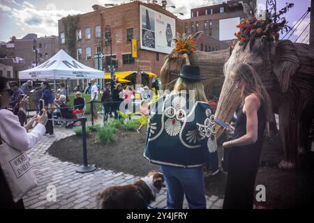 Le persone sono incantate dall'installazione d'arte pubblica Great Elephant Migration nel Meatpacking District di New York domenica 8 settembre 2024. Le 100 statue sono state create dal collettivo di coesistenza la cui missione aiuta le persone a condividere lo spazio con la natura magnifiche creature. Gli elefanti furono costruiti da artigiani indigeni indiani della Lantana camara, una specie di piante invasiva. L'installazione sarà visibile fino al 20 ottobre. (© Richard B. Levine) Foto Stock