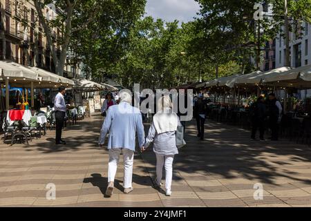 La gente passeggia lungo la Rambla, una delle zone pedonali più famose di Barcellona. Foto Stock