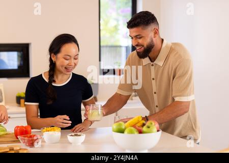 Amici in cucina, gustando bevande e preparando pasti sani insieme Foto Stock