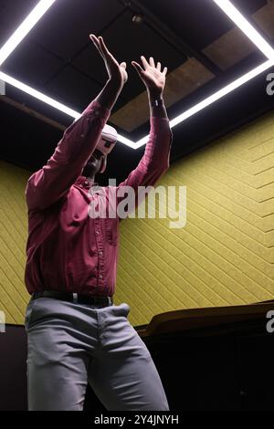 Utilizzando il visore VR, l'uomo in abiti da lavoro interagisce con l'ambiente virtuale Foto Stock