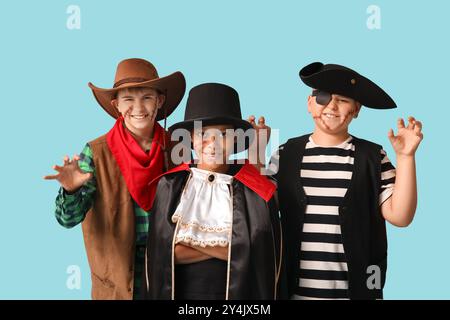 Ragazzi carini e felici in diversi costumi vestiti per la festa di Halloween su sfondo blu Foto Stock
