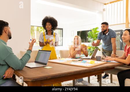 Avviare un'attività commerciale, collaborare in riunioni, giovani amici che discutono idee con notebook e appunti Foto Stock