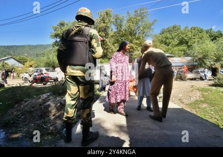 Dooru, India. 18 settembre 2024. La guardia di sicurezza controlla un vecchio prima di entrare per votare in un posto elettorale durante la prima fase delle elezioni di assemblea a Dooru, a sud di Srinagar, Jammu e Kashmir, il 18 settembre 2024. La Commissione elettorale dell'India (ECI) conduce la prima fase delle elezioni di assemblea in Kashmir da quando lo status speciale del territorio è stato revocato nel 2019. Crediti: Pacific Press Media Production Corp./Alamy Live News Foto Stock