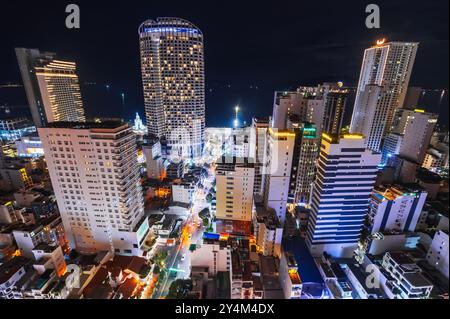 Vista notturna panoramica della città turistica di Nha Trang in Asia con grattacieli dall'alto da un drone. Nha Trang, Vietnam - 21 luglio 2024 Foto Stock