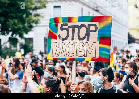 Vienna, Austria - 2 luglio 2020: Primo piano di una donna caucasica bianca che regge un cartello di cartone con la scritta "Stop Racism" tra un gruppo di Foto Stock