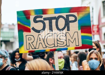 Vienna, Austria - 2 luglio 2020: Primo piano di una donna caucasica bianca che regge un cartello di cartone con la scritta "Stop Racism" tra un gruppo di Foto Stock