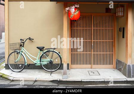 Natura morta con una bicicletta in piedi di fronte a una casa tradizionale nella parte vecchia di Kyoto, in Giappone Foto Stock