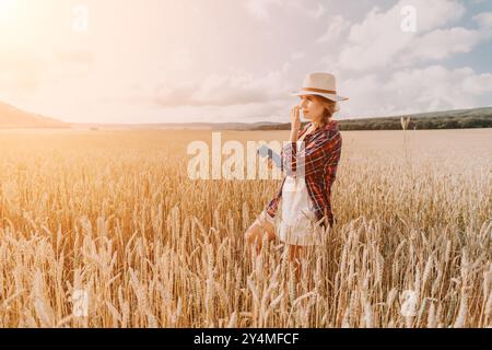 Donna campo di grano. Agronomo, agricoltore donna che controlla i picchi d'orzo maturo dorato nel campo coltivato. Primo piano della mano femminile sulla piantagione in agricoltura Foto Stock