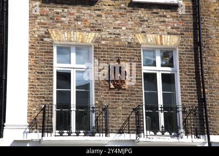 Cappotto d'arme con ferro di cavallo capovolto e trifoglio sull'edificio di Chelsea Londra Inghilterra (Heraldry) Foto Stock