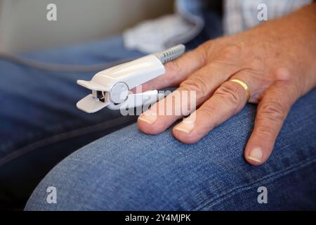 Primo piano di un pulsossimetro su pazienti dito utilizzato per misurare il polso e i livelli di ossigeno nel sangue Surrey England Foto Stock