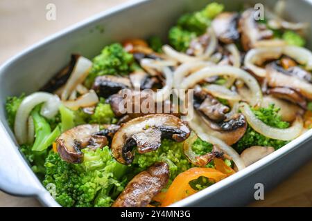 Funghi, broccoli, cipolla e peperoni in casseruola, cucina sana e mangiare con verdure, vegetariani e vegani, focalizzazione selezionata, ristretta Foto Stock