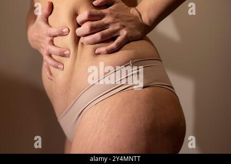 Primo piano di un corpo femminile che le stringe la pancia. Messa a fuoco morbida Foto Stock