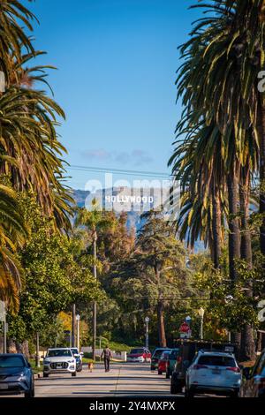 Los Angeles, Stati Uniti - 1° aprile 2024: Vista panoramica della famosa insegna di Hollywood attraverso le palme contro il cielo blu Foto Stock