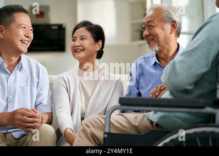 gruppo di felici riunioni asiatiche senior a casa con una bella chiacchierata Foto Stock