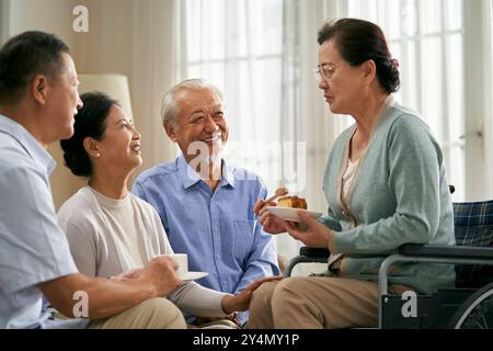 gruppo di felici riunioni asiatiche senior a casa con una bella chiacchierata Foto Stock