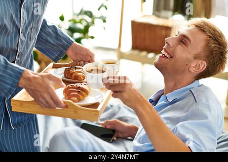 Una mattinata gioiosa si apre mentre una coppia amorevole fa colazione insieme mentre si rilassa nei pigiama. Foto Stock