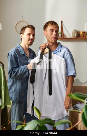 Una coppia condivide risate e calore insieme in pigiama, preparandosi per la giornata nella loro accogliente casa. Foto Stock