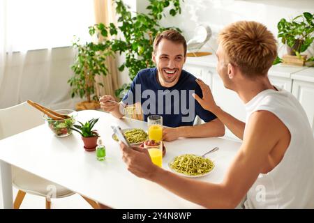 In una cucina moderna e luminosa, una coppia gioiosa che consuma un pasto, abbracciando il loro amore. Foto Stock