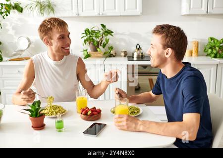 Una coppia gay amorevole che chiacchiera e pranza delizioso in cucina Foto Stock