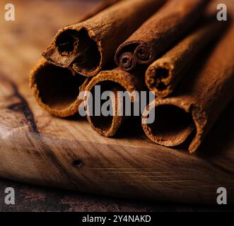 Bastoncini di cannella su sfondo di legno da vicino Foto Stock