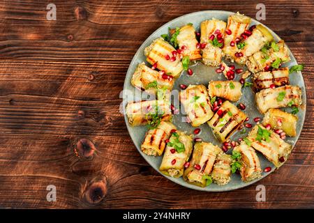 Involtini di melanzane fritti con noci, ripieno di aglio e decorati con melograno. Badrijani. Copia spazio. Foto Stock