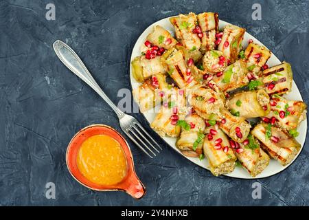 Involtini di melanzane fritti con noci, ripieno di aglio e decorati con melograno. Badrijani Foto Stock