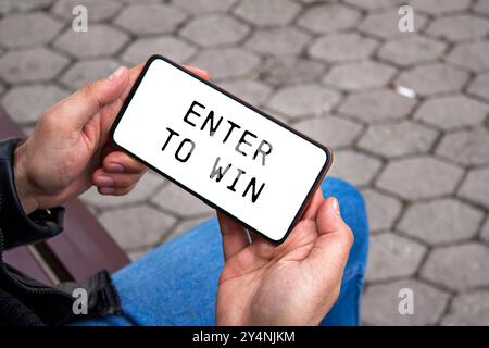 Immettere per vincere il messaggio scritto sullo schermo dello smartphone. Simbolo Conceptual Enter to win (Invio concettuale per vincere) Copia spazio. Foto Stock