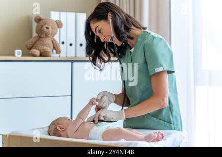 Il medico esamina il neonato durante l'appuntamento programmato presso la clinica Foto Stock