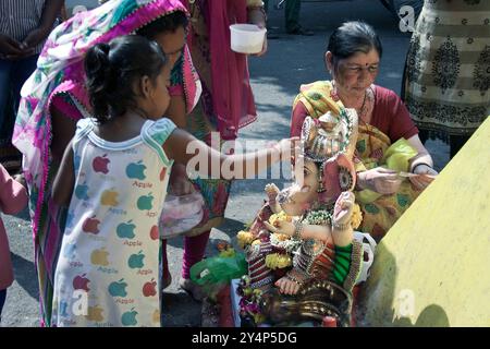 Vadodara, Gujarat / India - 15 settembre 2016: Una bambina esegue un rituale con un idolo di Ganapati durante il festival Ganesha. Foto Stock