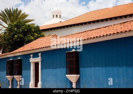 Casa coloniale ispano-americana caratterizzata dalle sue vivaci pareti blu, piastrelle di terracotta e finiture decorative bianche intorno alle finestre e alle porte Foto Stock