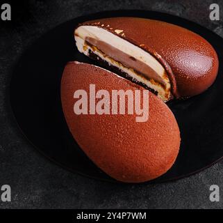 Mousse Cake Snickers su piatto nero Foto Stock