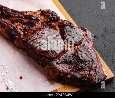 Grigliata di fresco bistecca Tomahawk sul tagliere di legno Foto Stock