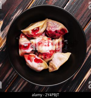 Gnocchi ripieni di ciliegia su piatto nero Foto Stock