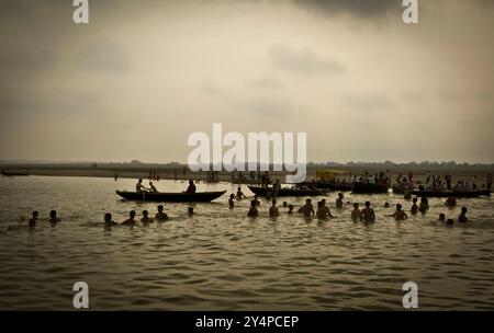 Piogge monsoniche, pellegrini e rituali di cremazione lungo il fiume Gange sono visti nella città Santa di Varanasi in India Foto Stock