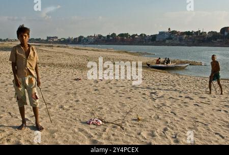 Piogge monsoniche, pellegrini e rituali di cremazione lungo il fiume Gange sono visti nella città Santa di Varanasi in India Foto Stock