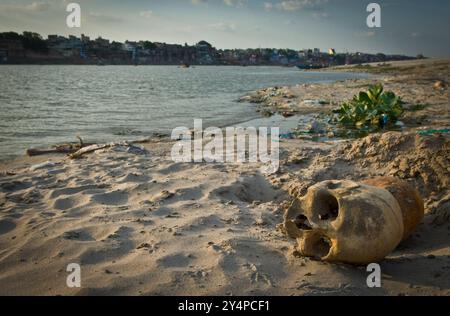 Piogge monsoniche, pellegrini e rituali di cremazione lungo il fiume Gange sono visti nella città Santa di Varanasi in India Foto Stock