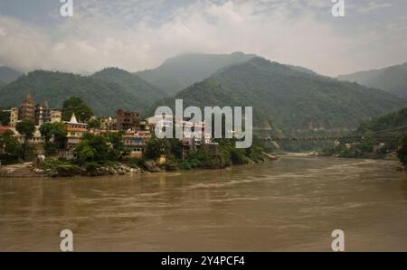 Piogge monsoniche, pellegrini e rituali di cremazione lungo il fiume Gange sono visti nella città Santa di Varanasi in India Foto Stock