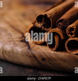 Bastoncini di cannella su sfondo di legno da vicino Foto Stock