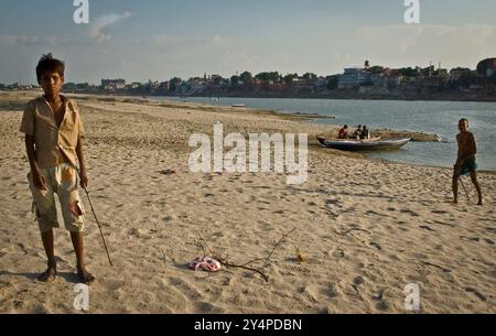 Piogge monsoniche, pellegrini e rituali di cremazione lungo il fiume Gange sono visti nella città Santa di Varanasi in India Foto Stock