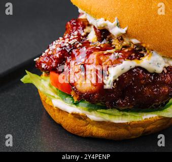 L'hamburger artigianale sta cucinando su un vassoio nero Foto Stock