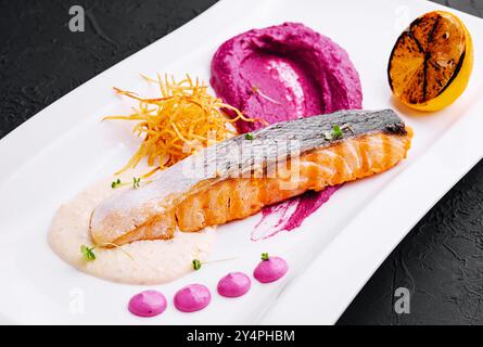 Salmone con purea di barbabietole e salsa panna Foto Stock