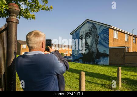 Manchester, Regno Unito. 18 settembre 2024. Un tifoso scatta una foto di un murale raffigurante Pep Guardiola, allenatore del Manchester City FC, durante la fase di UEFA Champions League 2024/25 partita di calcio tra il Manchester City FC e l'FC Internazionale. Crediti: Nicolò campo/Alamy Live News Foto Stock