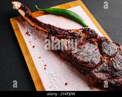 Grigliata di fresco bistecca Tomahawk sul tagliere di legno Foto Stock